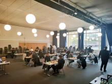 Überblick über den Spielsaal mit vielen einzelnen Tischen und Spielern